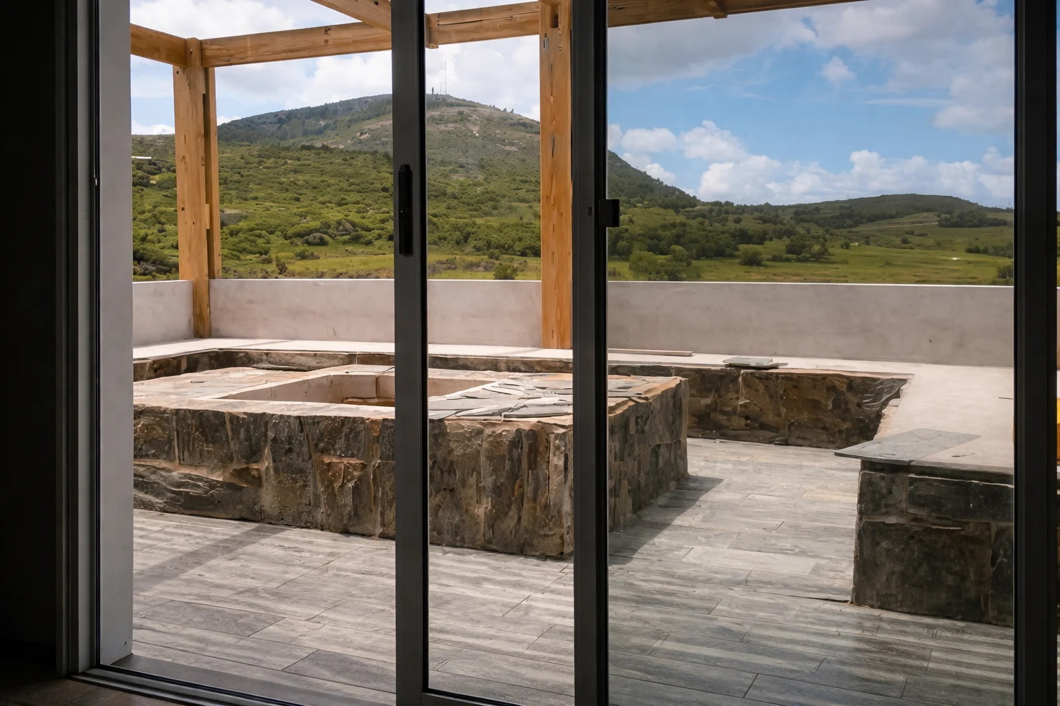 Vista interior hacia la galería y el paisaje serrano, con fogón exterior integrado al espacio social.